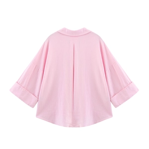 Detail view of pink oversized shirt back with box pleat and curved hemline texture