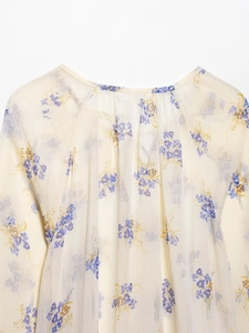 Close-up of lightweight floral chiffon blouse with sheer texture and pleated collar details
