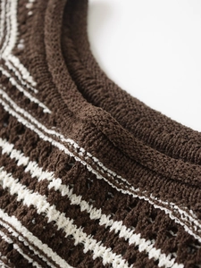 Close-up of the woven texture and wavy stripe pattern on a brown knit sweater vest