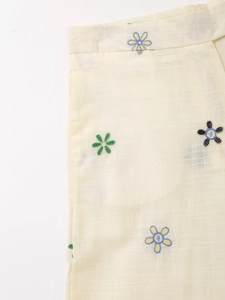 Detail der bestickten kleinen Blumenmuster auf cremefarbener Baumwoll-Leinen-Hose