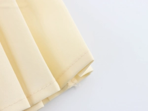 Vue macro détaillée des plis en tweed jaune et des coutures soignées sur une robe d'été