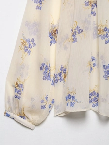 Detailed view of lightweight floral print chiffon fabric with elegant cuffed sleeve details