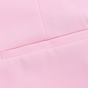 Detail of pink fabric texture featuring a flap pocket and professional stitching on blazer