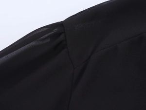 Detail shot of black chiffon shirt shoulder showing pleated design and fine stitching