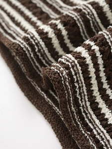 Close-up of the high-quality crochet knit fabric texture with brown and beige stripes