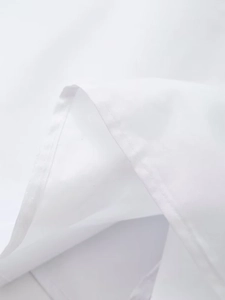 Macro shot of fine double stitching and premium white cotton fabric texture on the dress