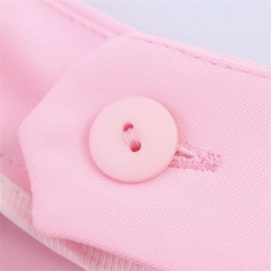 Detailed macro view of baby pink suit sleeve featuring matching round button and fine texture