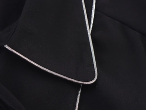 Close-up of black shirt collar featuring exquisite silver metallic piped edge detail