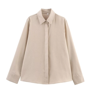 Détail du col d'une chemise beige à manches longues avec étiquette S et texture lisse