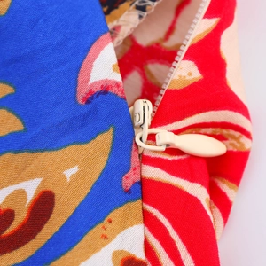 Detailed close-up of a hidden zipper and vibrant ethnic floral print on a summer dress