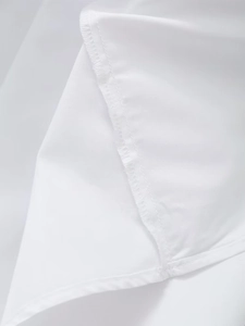 Close-up of high-quality overlock stitching and double-needle hem on a white dress
