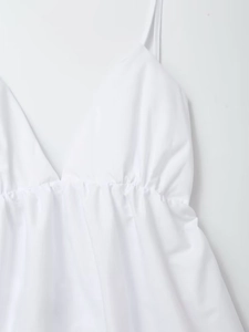 Detail of white V-neck dress with thin straps and elegant elastic pleated waist design