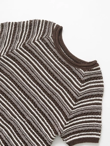 Close-up of brown and white striped knit fabric showing intricate crochet texture