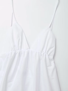 Detail view of white V-neck dress featuring delicate spaghetti straps and waist pleats