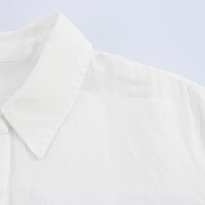 Détail du col et de l'épaule d'une chemise en lin blanc avec texture du tissu