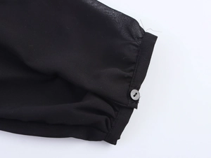 Detailed macro view of black chiffon shirt cuff with button and contrast stitching