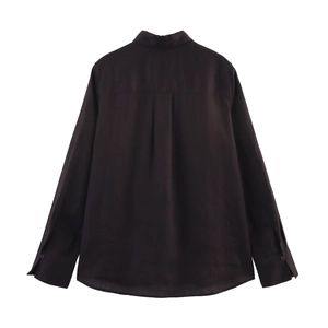 Détail du pli d'aisance au dos et de la coupe ajustée d'une chemise sombre à manches longues