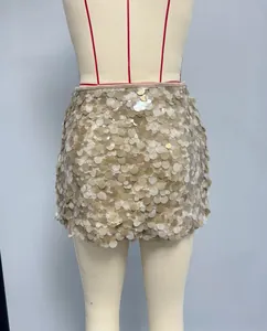 Close-up of champagne gold sequin mini skirt showing metallic shimmer and layered texture