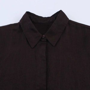 Gros plan du col de chemise en lin marron foncé avec texture et patte de boutonnage