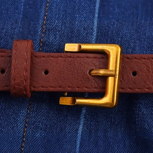 Cintura in pelle marrone con fibbia rettangolare dorata su jeans blu da donna