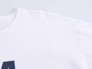 Detail of crew neckline and reinforced shoulder seams on a white cotton t-shirt