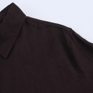 Détail du col et de la couture d'épaule d'une chemise marron foncé en tissu de haute qualité