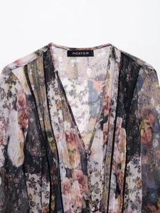 Détail d'une robe fleurie vintage avec col en V, boutons en tissu et bordure dentelle