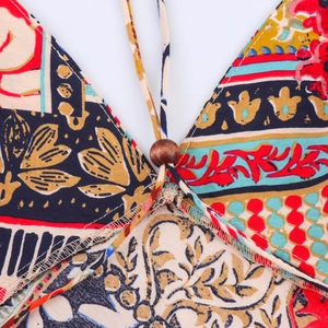 Detail of bohemian print dress featuring V-neckline with wooden bead and tie drawstring