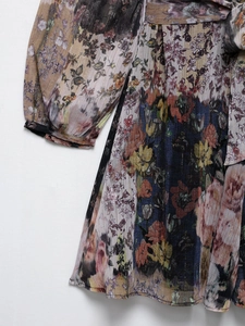 Détail du tissu plissé floral avec rayures dorées et poignets élastiques sur la robe