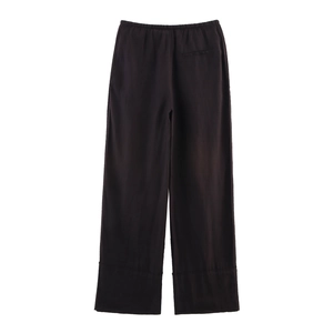 Détail de la taille haute élastique et de la poche arrière sur le pantalon marron à jambe large