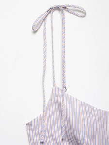 Detail eines orange-blau gestreiften Sommerkleides mit filigranen Bindeträgern