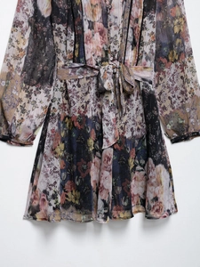 Gros plan du tissu floral de la robe avec fils métalliques et détails de boutons