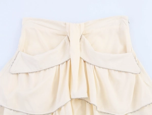 Detail of light beige skirt with beaded ruffle edges and invisible side zipper closure