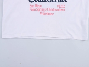 Close-up of retro San Diego graphic print and double-needle hem on white cotton T-shirt