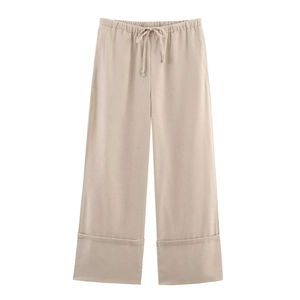 Détail du pantalon large beige avec taille élastique à cordon et design d'ourlet revers