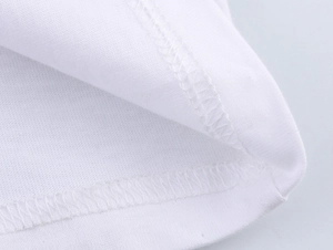 Macro shot of white cotton t-shirt hem featuring precise double-needle stitching detail
