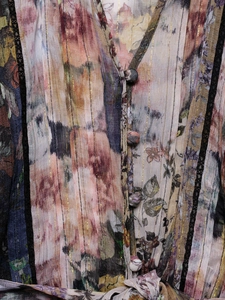 Détail d'une robe florale vintage avec boutons en tissu et bordures en dentelle noire