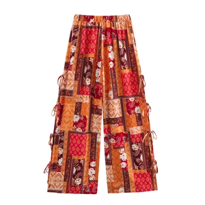 Women's boho wide-leg pants with vibrant paisley print, side slits and tie-up details