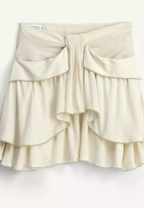 Detail of cream ruffled mini skirt featuring intricate silver beaded trim and satin texture