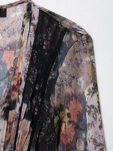 Détail du tissu mousseline florale avec rayures dorées et dentelle noire délicate