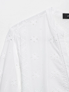 Détail d'une robe chemise blanche en coton avec broderie anglaise et dentelle ajourée
