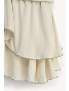 Detail of cream tiered ruffles with silver bead chain trim on an A-line skirt