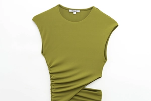 Detailed close-up of olive green sleeveless dress with side cutout and ruching details