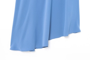 Detail of blue dress hem featuring irregular cut and precise rolled edge stitching