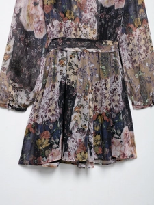 Détail d'une robe fleurie vintage avec rayures métalliques et poignets boutonnés