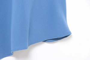 Detail of double-stitched hem and fine plain weave fabric in sky blue on a summer dress