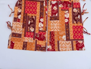 Detail of bohemian paisley print trousers featuring side drawstring and colorful patterns