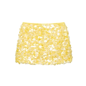 Close-up of bright yellow sequin mini skirt with reflective round paillette details