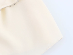Detail of cream fabric texture with silver bead chain edge on French ruffles skirt