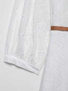 Détail de robe blanche en broderie anglaise avec manche lanterne et ceinture fine